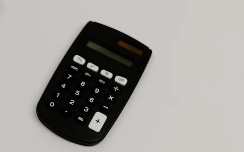 Calculatrice posée sur un bureau clair, pour estimer le budget d'un projet de pompe à chaleur
