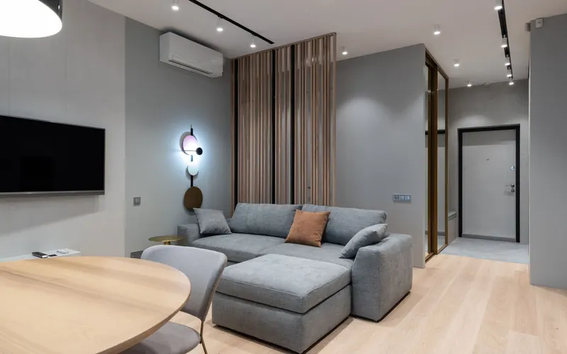 Salon contemporain avec une unité murale de pompe à chaleur air-air au-dessus du canapé